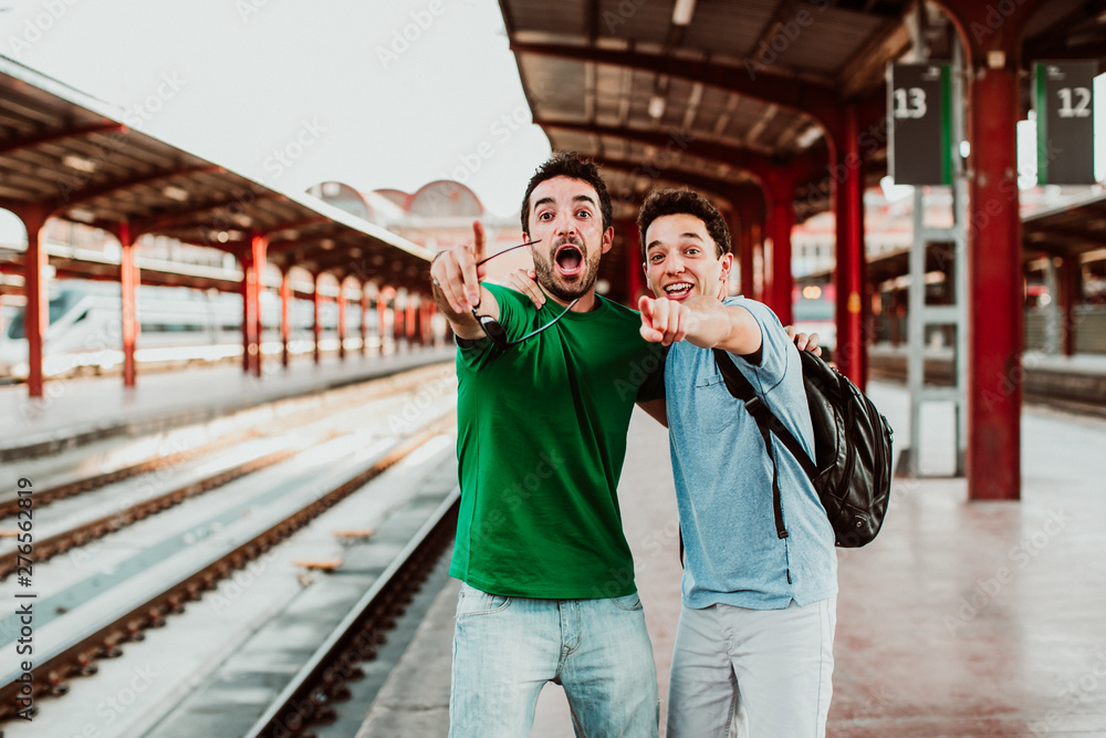 .Two brothers on the platform waiting for the train. Relaxed and fun to start their vacation. Lifestyle. Travel photography