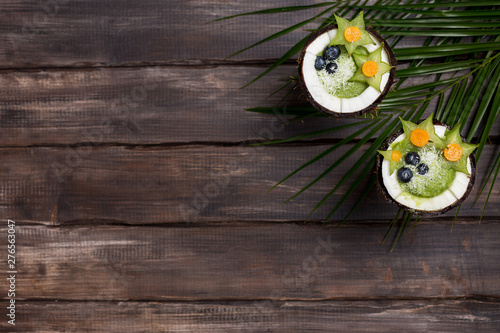 Smoothie in coconut on wood background