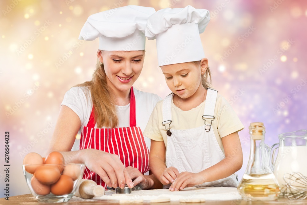 Portrait of adorable little girl and her mother baking together Portrait of adorable little girl and her mother baking together