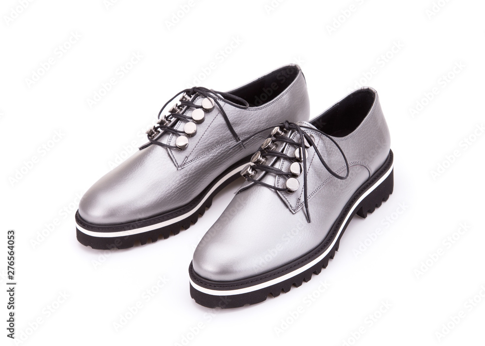 A pair of silver shoes on a cord. Silver shoes from silvery skin isolate on a white background.