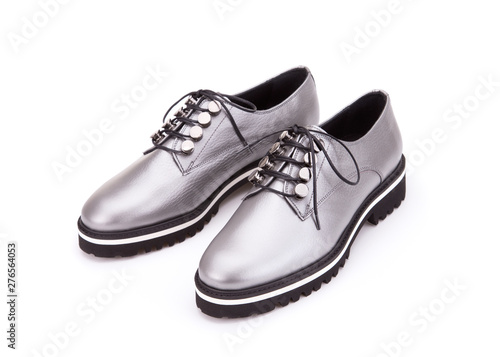 A pair of silver shoes on a cord. Silver shoes from silvery skin isolate on a white background. © fortton