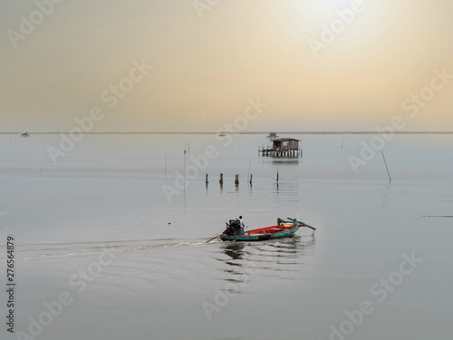 Coastal fishing boats are sailing after raining on sunset at the bay of Bangsaen, Thailand. photo