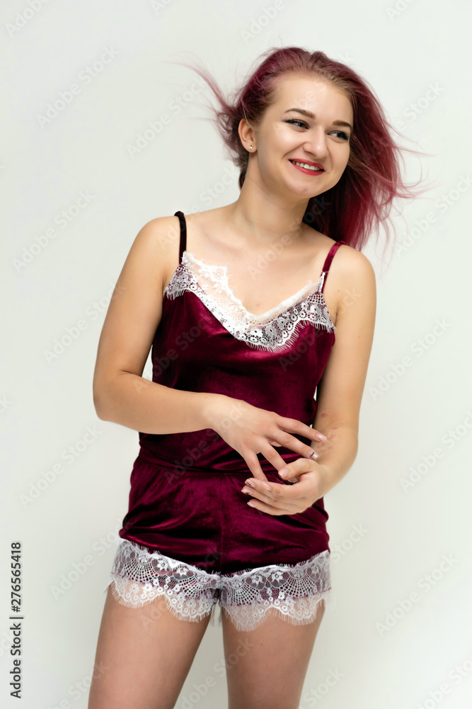 Concept portrait of a knee-high pretty sexy girl with purple hair in beautiful red lingerie on a white background. She smiles, happy with life, happy. Hair flying, front view. Made in a studio. Concept portrait of a knee-high pretty sexy girl with purple hair in beautiful red lingerie on a white background. She smiles, happy with life, happy. Hair flying, front view. Made in a studio.