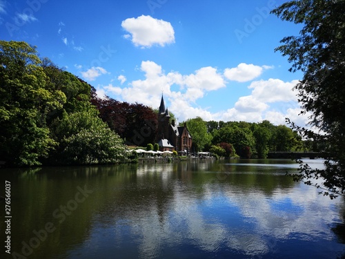 Walk on the canals and bridges of Bruges. Castle view and green park by a sunny summer © Guillaume