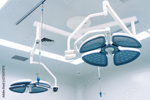 Working surgeon on the background of surgical lamp.