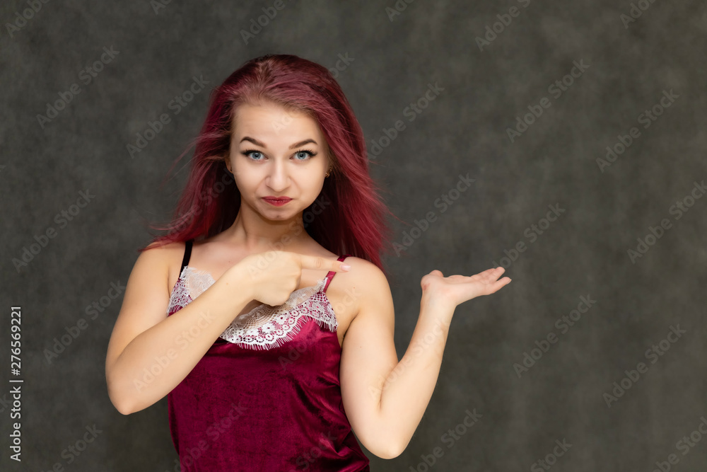 Concept portrait of a pretty sexy girl with purple hair in beautiful red lingerie on a gray background. She smiles, happy with life, happy. Hair flying, front view. Made in a studio. Concept portrait of a pretty sexy girl with purple hair in beautiful red lingerie on a gray background. She smiles, happy with life, happy. Hair flying, front view. Made in a studio.