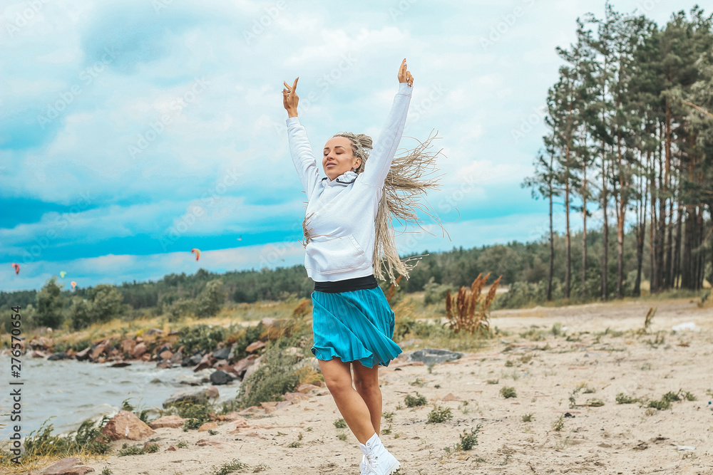 beautiful, slim woman with blonde pigtails resting, running, jumping on the shore of the sea. vacation, joy, happiness, rest beautiful, slim woman with blonde pigtails resting, running, jumping on the shore of the sea. vacation, joy, happiness, rest