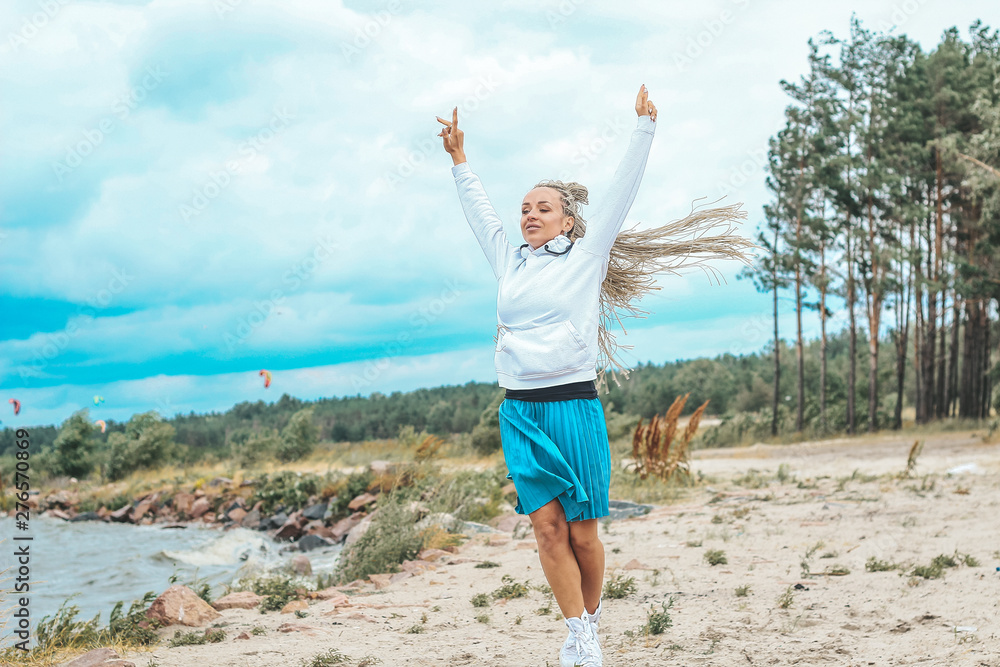 beautiful, slim woman with blonde pigtails resting, running, jumping on the shore of the sea. vacation, joy, happiness, rest beautiful, slim woman with blonde pigtails resting, running, jumping on the shore of the sea. vacation, joy, happiness, rest