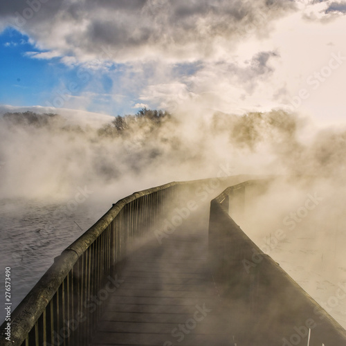Un puente en el lago con vapor y humo por actividad geotermica