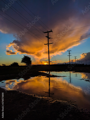 Φωτογραφία Atardecer con nubes en el cielo color naranja y el reflejo en el agua