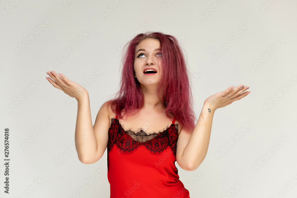 Concept portrait of a pretty sexy girl with purple hair in beautiful red lingerie on a white background. She smiles, happy with life, happy. Hair flying, front view. Made in a studio. Concept portrait of a pretty sexy girl with purple hair in beautiful red lingerie on a white background. She smiles, happy with life, happy. Hair flying, front view. Made in a studio.