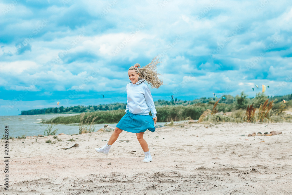 beautiful, slim woman with blonde pigtails resting, running, jumping on the shore of the sea.  vacation, joy, happiness, rest