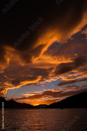 Cielo con nubes color naranja despues de la tormenta y el lago calmado