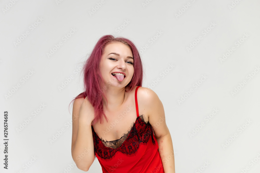 Concept portrait of a pretty sexy girl with purple hair in beautiful red lingerie on a white background. She smiles, happy with life, happy. Hair flying, front view. Made in a studio. Concept portrait of a pretty sexy girl with purple hair in beautiful red lingerie on a white background. She smiles, happy with life, happy. Hair flying, front view. Made in a studio.