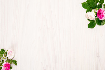 Flowers composition. Frame made of white and pink rose flowers on wooden background. Flat lay, top view, copy space