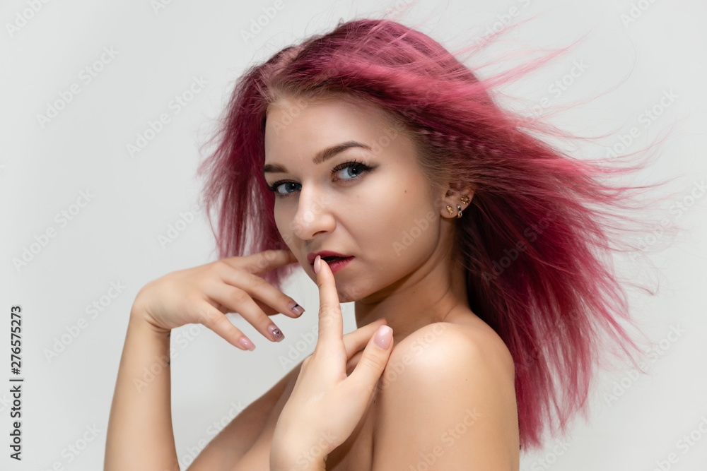 Concept portrait of a close-up of a pretty sexy girl with purple hair on a white background. She smiles, happy with life, happy. Hair flying, front view. Made in a studio. Concept portrait of a close-up of a pretty sexy girl with purple hair on a white background. She smiles, happy with life, happy. Hair flying, front view. Made in a studio.