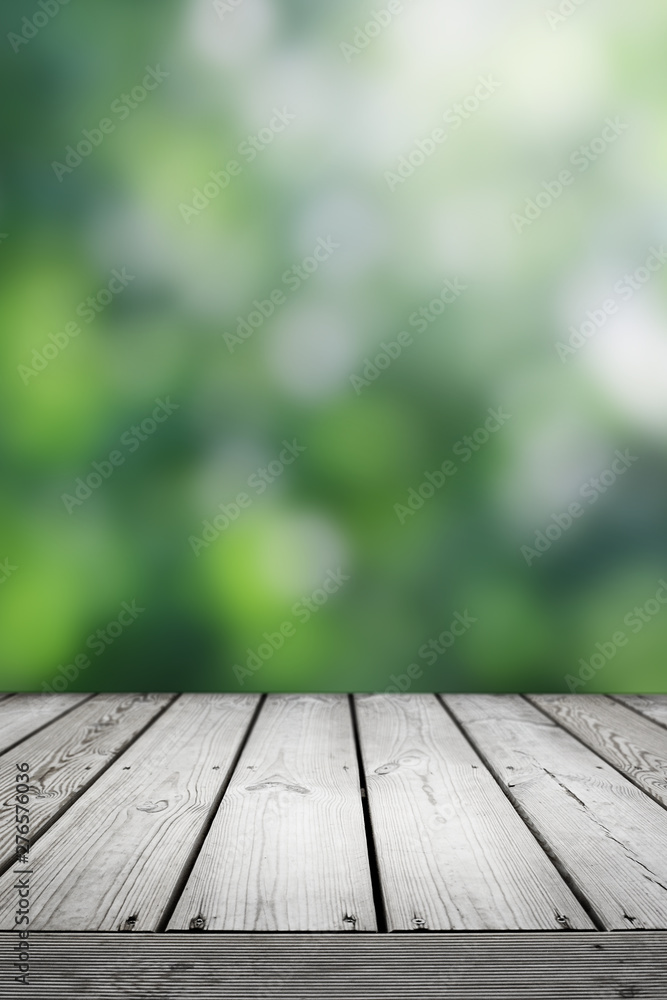Blurred abstract green bokeh and wooden table background. Blurred abstract green bokeh and wooden table background.