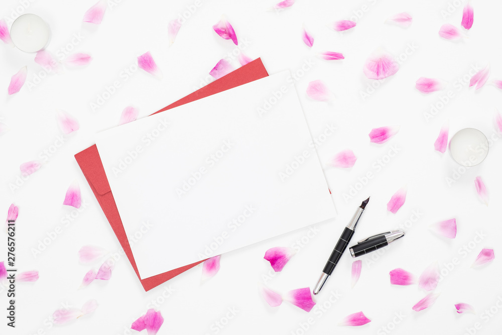 Top view blank paper card, red envelope, rose flowers petals on white background. Minimal flat lay style composition, Love letter, greeting card concept. Top view blank paper card, red envelope, rose flowers petals on white background. Minimal flat lay style composition, Love letter, greeting card concept.