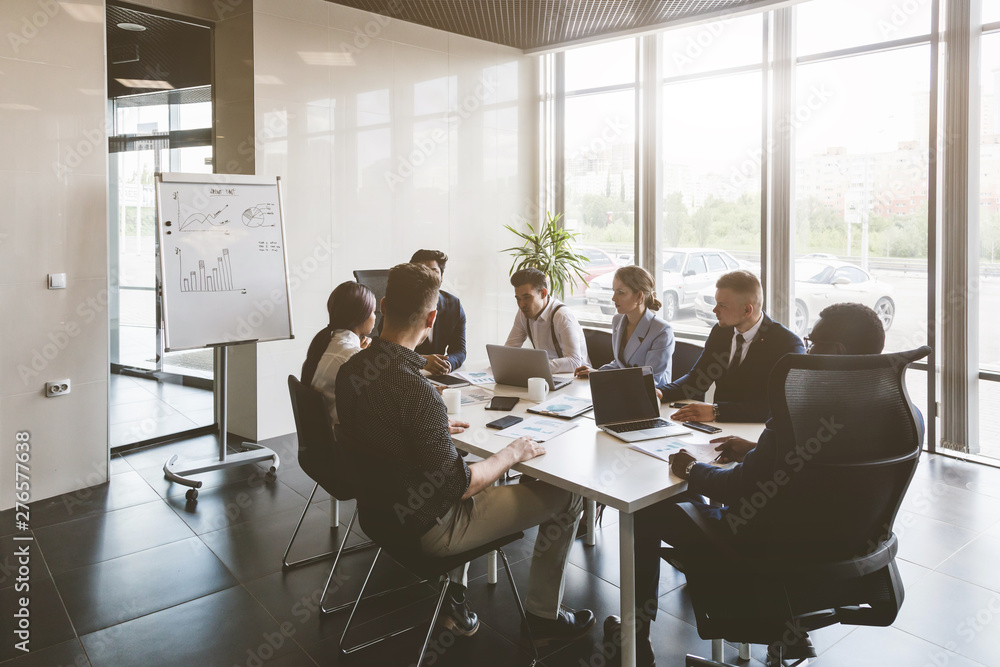 A team of young businessmen working and communicating together in an office. Corporate businessteam and manager in a meeting. A team of young businessmen working and communicating together in an office. Corporate businessteam and manager in a meeting.