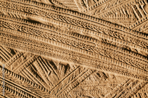 Vászonkép Tyre mark shape lines on dry yellow sand pattern.