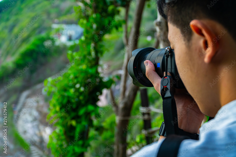 Good looking Asian photographer man taking photo in the nature. Good looking Asian photographer man taking photo in the nature.