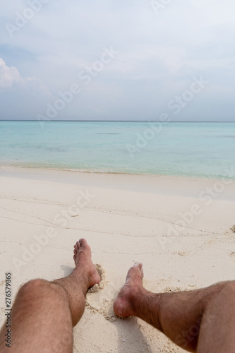 Relax on the beach. In the frame of the guy's feet.