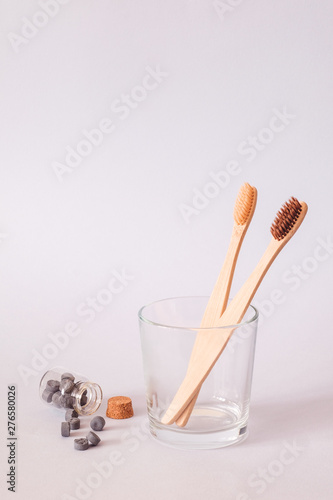 Bamboo toothbrush and dry tooth paste or toothpaste tablets on blue background. Zero waste, ecological concept.