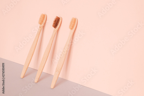 Bamboo toothbrush on pink blue background. Zero waste, ecological concept.