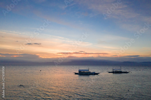 Sunset over the sea, top view. Seascape with boats. Traditional Philippine boats.