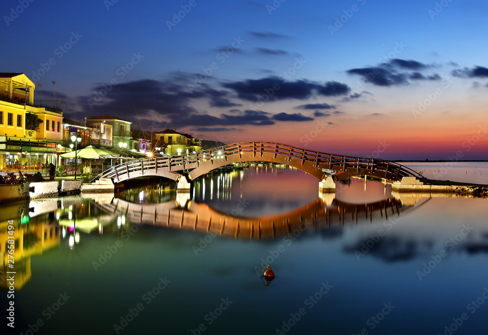 Obraz premium Sunset at Lefkas (Lefkada) town, at the small marina for the fishing boats with the nice wooden bridge. Ionian sea, Greece.