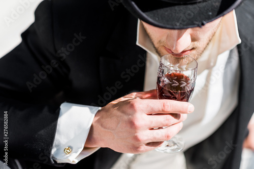 overhead view of victorian man holding wine glass with drink