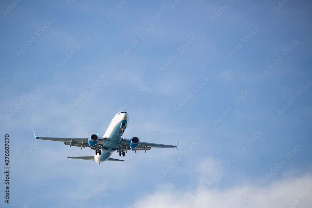Fototapeta White airplane flying against a white sky