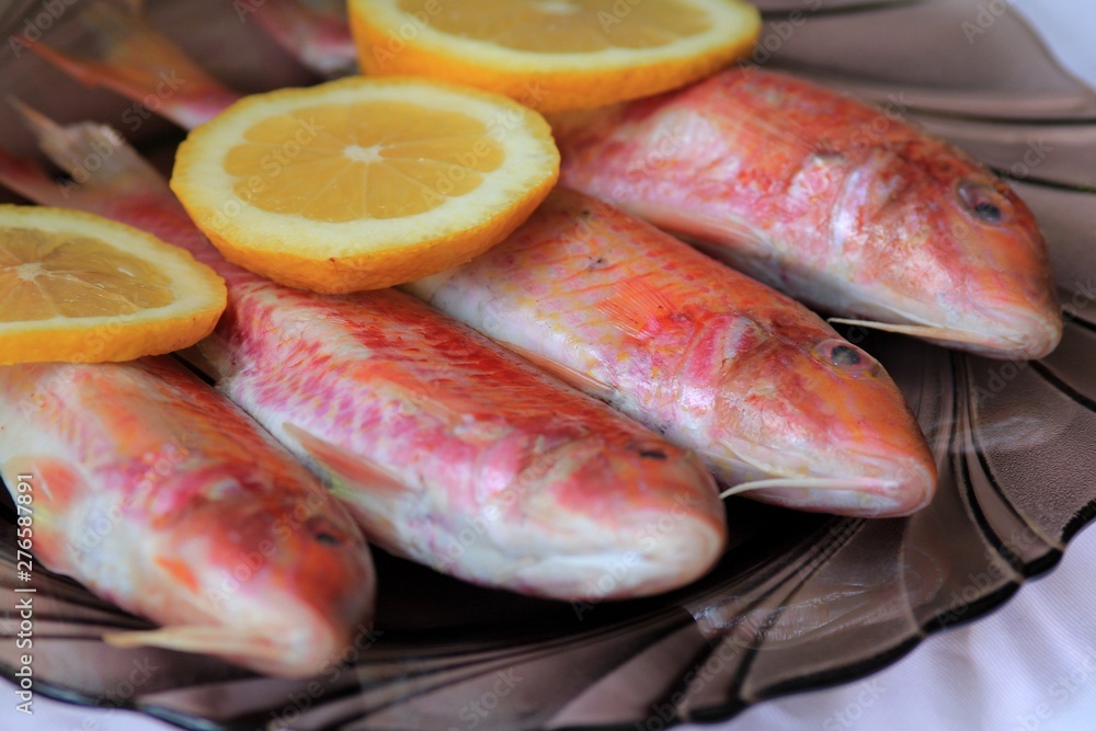 Fresh fish Mullus barbatus in the dish with lemon Fresh fish Mullus barbatus in the dish with lemon