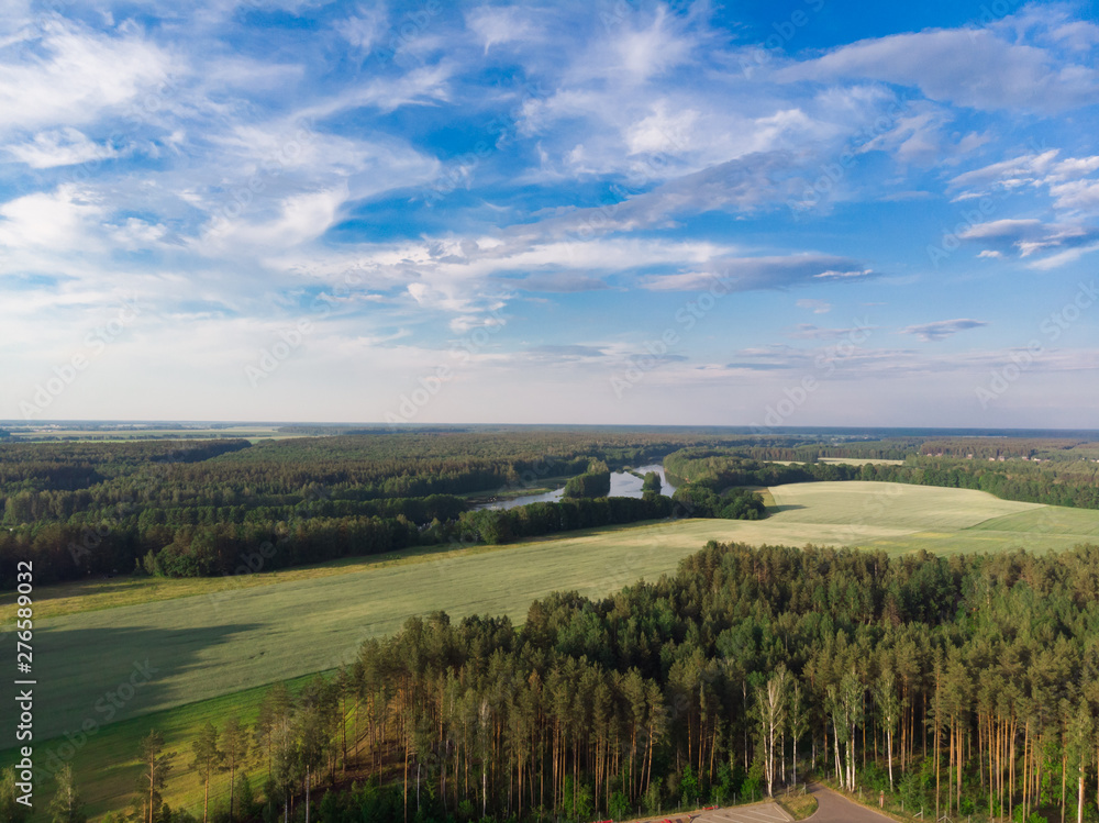 Nature in the summer. Forests, fields, meadows, lake, river and village. View from the sky. The photo was taken by a copter. Panorama. The concept is a favorable environment. Blue sky. Background.