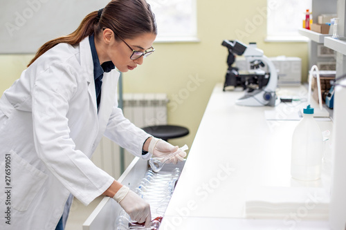 Young woman working in laboratory on some experiment