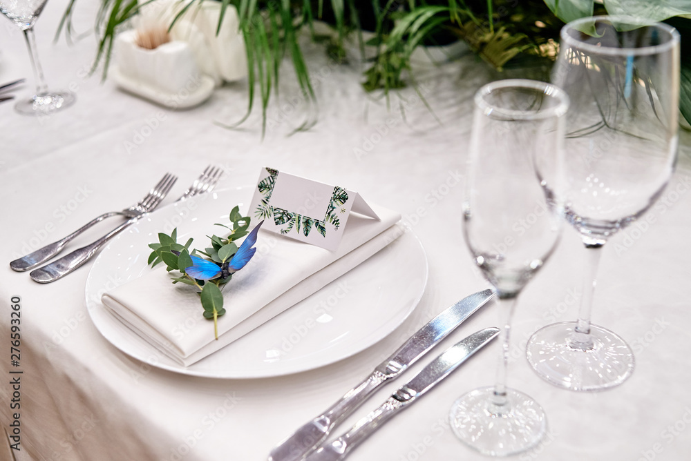 Table setting with blank guest card on empty white plate and cutlery on table, copy space. Menu mockup, place setting at wedding reception. Table served for wedding banquet in restauran Table setting with blank guest card on empty white plate and cutlery on table, copy space. Menu mockup, place setting at wedding reception. Table served for wedding banquet in restauran