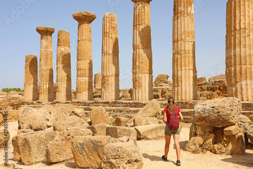 Young woman walking in the Valley of the Temples Agrigento, Sicily. Traveler girl visits Greek Temples in Southern Italy.