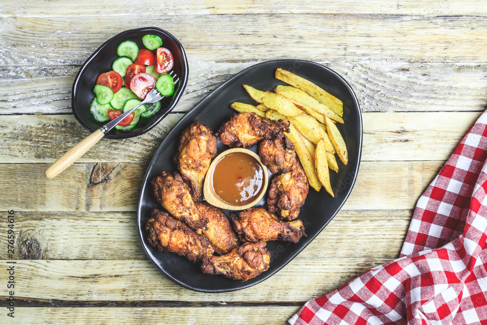 Grilled chicken wings on wooden background.