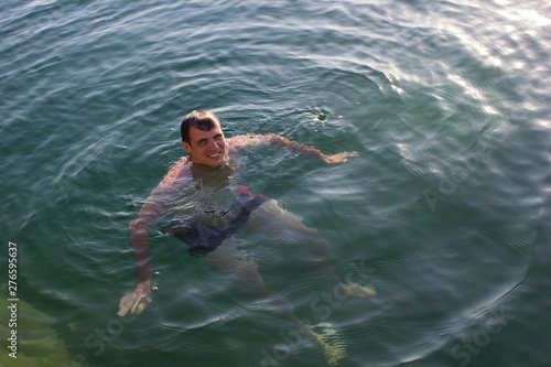 Male young swimmer on the water - summer sea