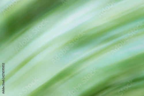 Defocused dynamic abstract green background. Emerald motion effect decorative backdrop. Natural summer blurry light and dark green texture. Fresh no focus plant leaves creative wallpaper