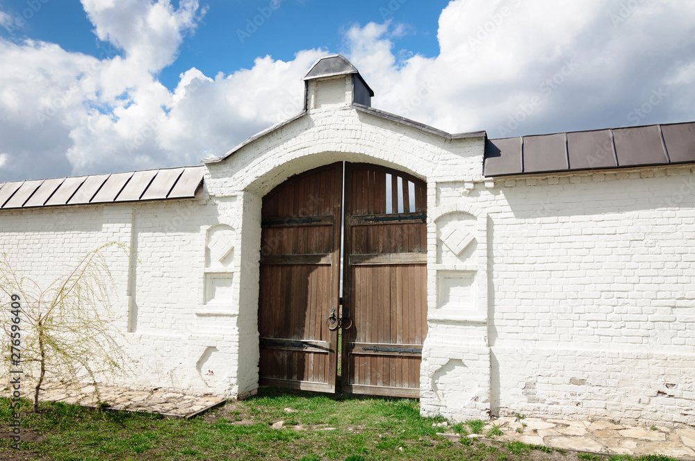 Old wooden gate in white stone wall. Old wooden gate in white stone wall.
