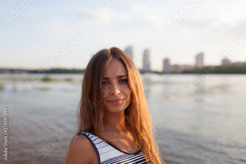 Closeup portrait of effective girl with long hair smiling to camera having fun on the beach,vacation mood