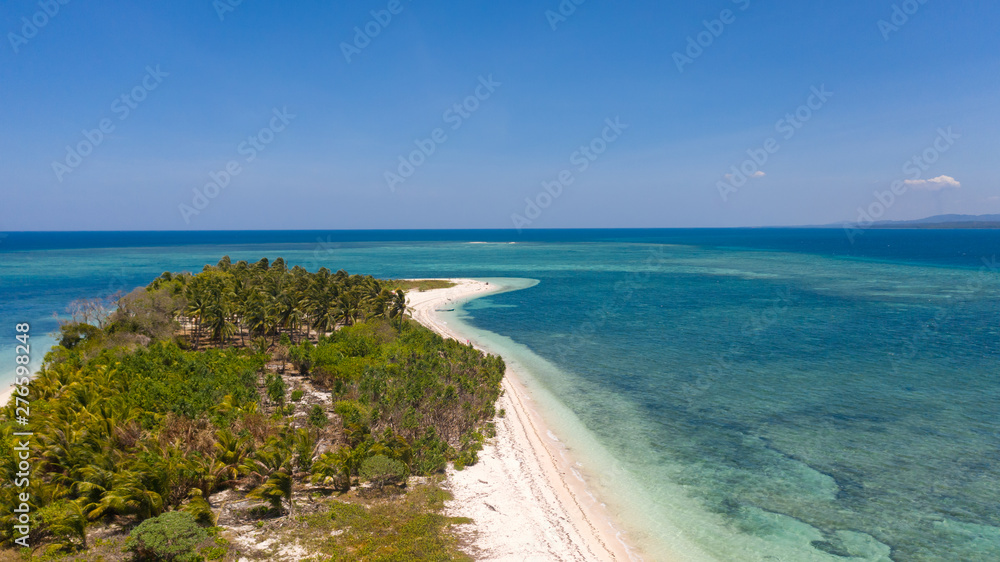 Tropical island Canimeran. White sandy beach on a desert island. Small island with palm trees and white sand.