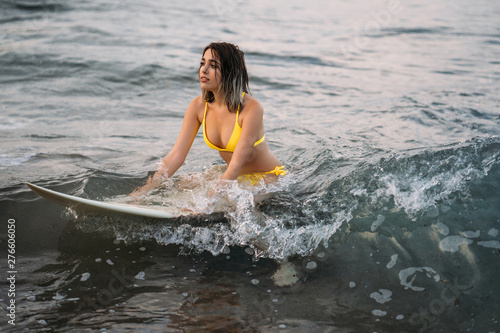 Blonde Surfer Woman in bikini with surf board dive under ocean wave lip. Underwater sport activity with fun. Family lifestyle,water sport lessons and beach swimming activity on summer vacation.