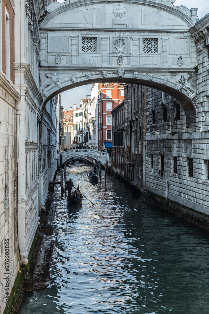 VENICE, ITALY - JAN 1, 2016: The Bridge of Sighs (Ponte dei Sospiri) with gondola passing under. The bridge was the last view that convicts saw before their imprisonment. Handheld shot.