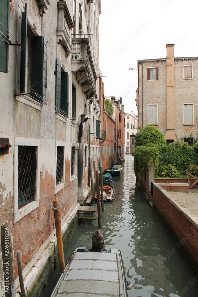 Side canal in Venice with small boats