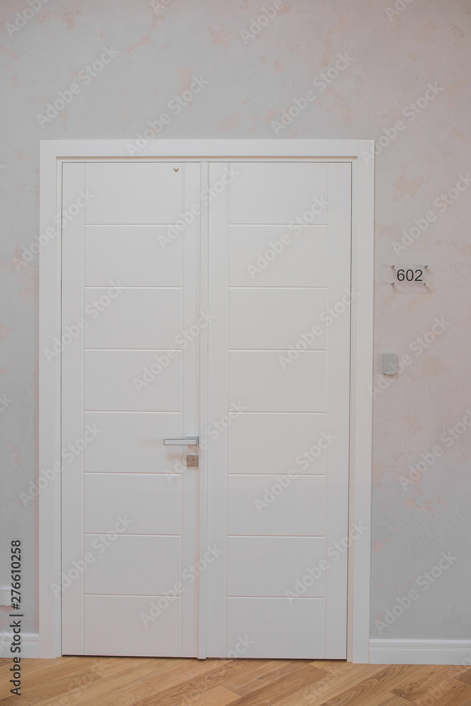 White wooden office door with silver handle, with number plates White wooden office door with silver handle, with number plates