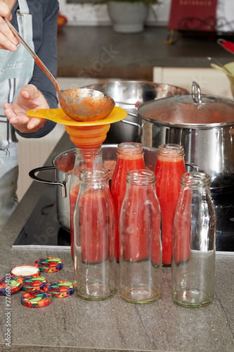 hausfrau beim tomaten einkochen in moderner küche