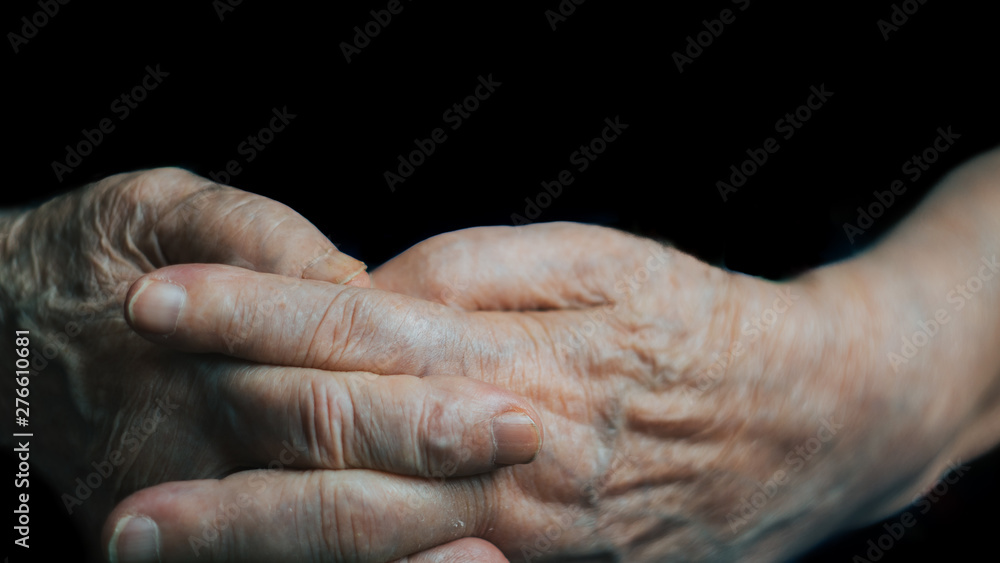 Elderly woman hand palm. Old lady arms, freckles. Isolated black background, close up, overhead, copy space. Coronavirus risk group. COVID virus infection.