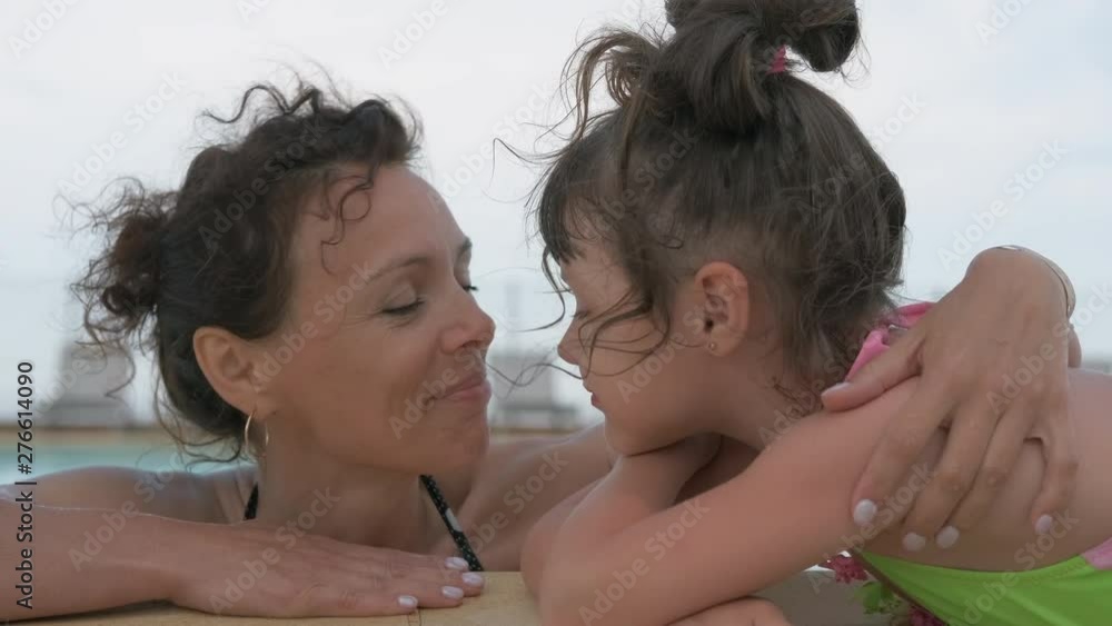 Portrait of mother with child in outdoor pool. Happy mom with her daughter by the pool at the resort. Portrait of mother with child in outdoor pool. Happy mom with her daughter by the pool at the resort.